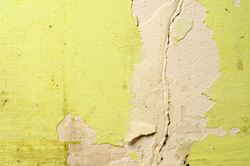 Green damaged plaster on concrete wall, old plaster needs repair. Abstract background, close-up, copy space