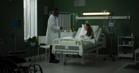 Doctor enters the room with a tablet, ready to review the patient's progress.