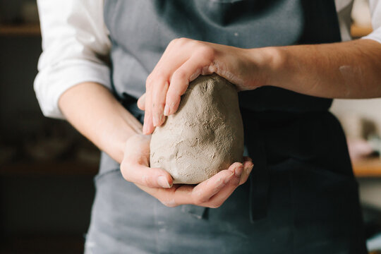 Potter holds a piece of wet clay in their hands, molds it into form. Process of creating ceramic products.