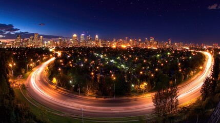 Fototapeta premium Night cityscape panorama highway curves around illuminated suburbs towards city skyline
