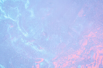 The surface showcases a captivating blend of icy textures, with subtle variations in color ranging from cool blues to warm pinks, reflecting the beauty of twilight.