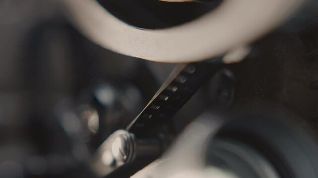 Close ups of a vintage 8MM projector spools moving and playing film 