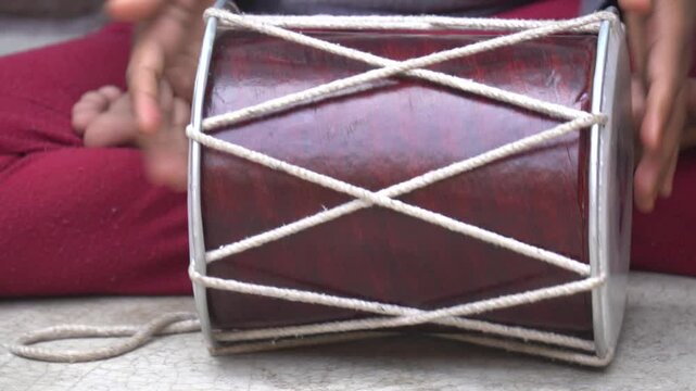 Traditional dholak drum with dual heads, used in folk music and celebrations, delivers rich rhythmic beats for festive and cultural events
