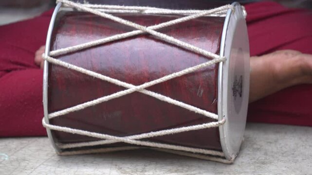Traditional dholak drum with dual heads, used in folk music and celebrations, delivers rich rhythmic beats for festive and cultural events