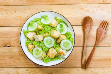 A plate of tofu salad on a wooden table.Diet food.Meat substitute.