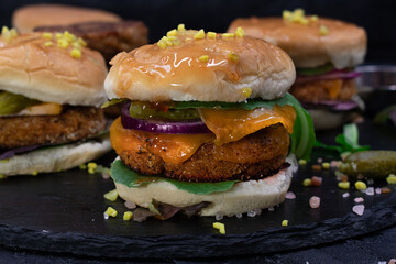 Vegan meatless seitan cheeseburger and vegan on slate plate