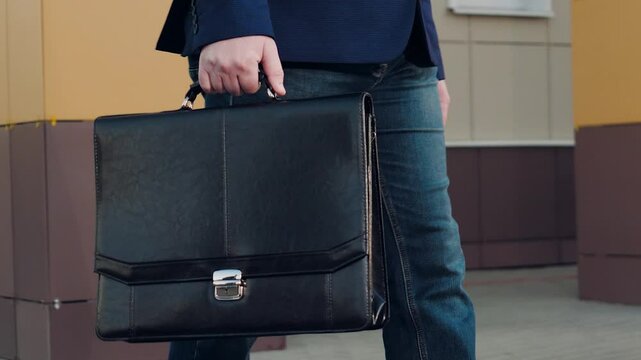Businessman holds briefcase willing to attend significant event. Businessman carries briefcase concentrating on upcoming meeting. Busy man walks with briefcase containing necessary materials for event