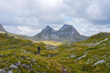 Fototapeta premium Female hiker alone on Prutas Peaks trail with Mount Sedlo in the distance 