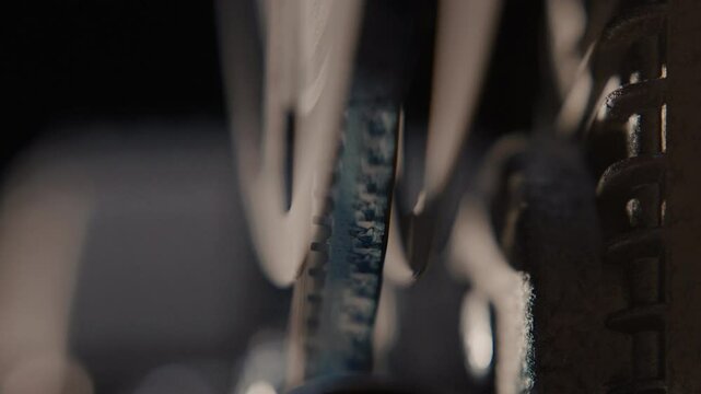 Close ups of a vintage 8MM projector spools moving and playing film 
