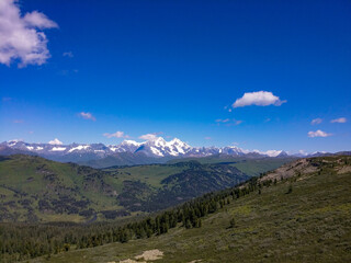 view of the gorge against the background of forest, mountains and blue sky with clouds