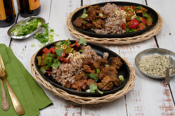 Vegan buckwheat and seitan with roasted vegetables on cast iron dish
