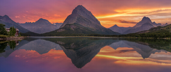 Sunset panorama from the Many Glacier Hotel - reflection on Swiftcurrent Lake of Grinnell Point mountain - Glacier national Park
