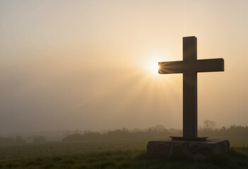 Silhouette of cross in foggy meadow at sunrise, spiritual reflection