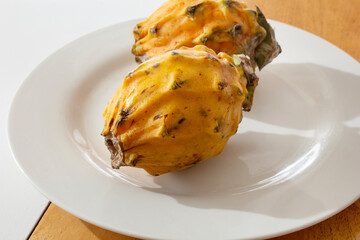 A view of a yellow dragon fruit on a plate.