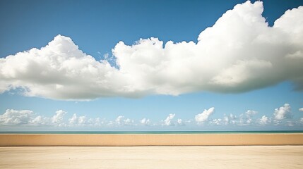 Bright blue sky meets tranquil sea, with soft clouds floating ab