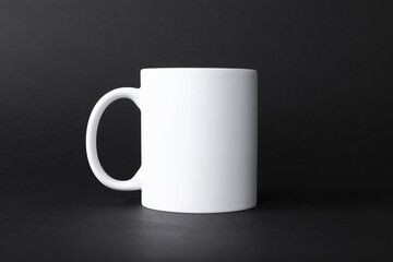 One blank white mug on black background. Mockup for design