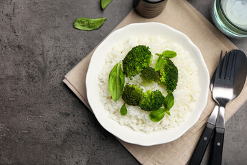 Tasty rice with broccoli served on grey table, top view. Space for text