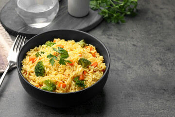 Tasty rice with vegetables on grey table, closeup. Space for text