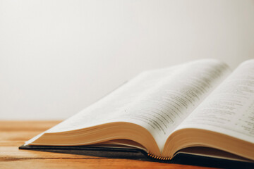 Open Holy Bible in English language on wooden table, closeup