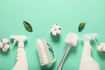 Flat lay composition with spray bottles of different cleaning products, brushes and cotton flowers...