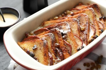 Freshly baked bread pudding in baking dish on table, closeup