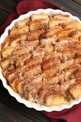 Delicious bread pudding with raisins and cinnamon on wooden table, top view