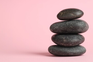 Stack of rocks on pink background, space for text. Harmony and life balance
