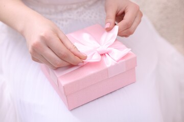 Bride opening beautiful wedding gift indoors, closeup