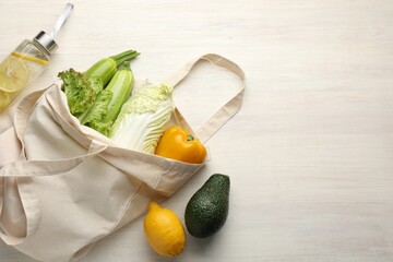 Shopper bag with products on white wooden background, top view and space for text. Eco friendly lifestyle