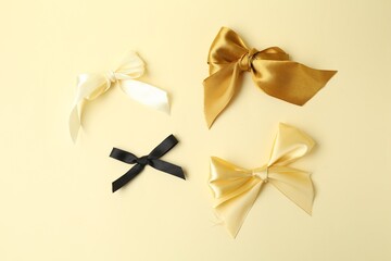Beautiful bows of different colors on beige background, flat lay. Racism concept