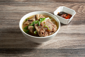 A view of a small bowl of oxtail in broth.