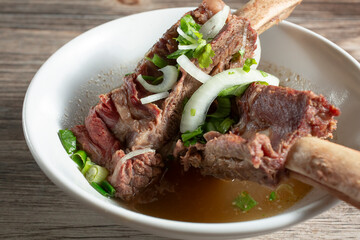A closeup view of a bowl of beef back ribs.