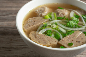 A closeup view of a bowl of meatball soup.