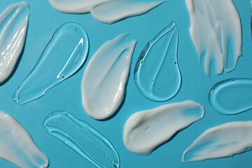Body cream and gel on light blue background, flat lay
