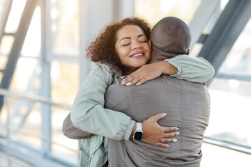 Welcome back. Happy african woman embracing her loving boyfriend, free space. High quality photo
