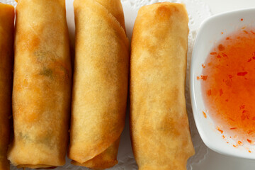A top down view of a plate of egg rolls.