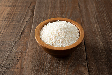A view of dry tapioca pearls, in a wood bowl. 
