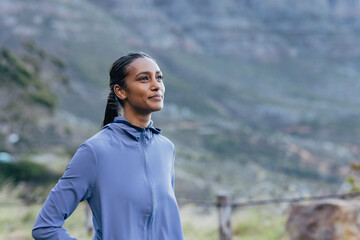 Portrait of a positive woman enjoying a morning walk against a stunning view in the natural park