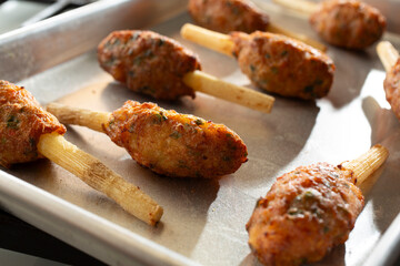 A view of a metal pan of sugar cane shrimp.