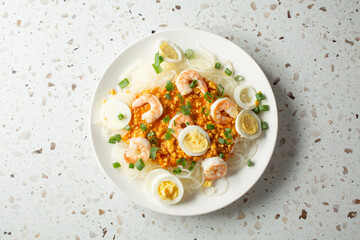A top down view of a plate of pancit palabok.