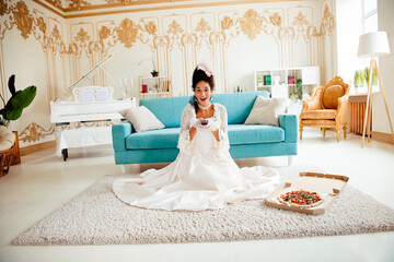 Elegant Woman in Renaissance Style Gown Enjoying Modern Comforts of Home on a Relaxed Day