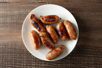 A top down view of several longanisa, on a plate.