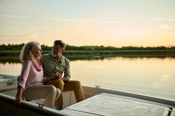 Senior couple enjoying romantic sunset boat trip