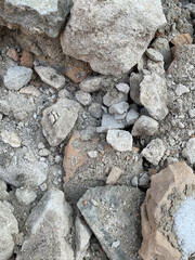 Cracked ground texture with scattered rocks, soil, and natural debris