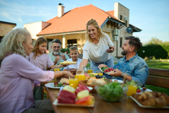 Happy extended family having lunch together in the backyard