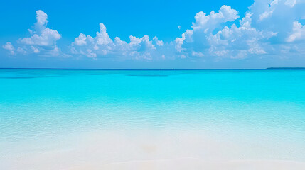 Fototapeta premium Crystal clear turquoise water meets soft white sand under a bright blue sky at a tropical beach