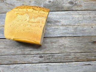 tasty piece of black bread lies on a wooden table