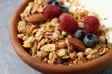Delicious granola with berries and yogurt on a light background