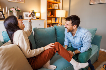 Couple laughing while playing leisure games at home