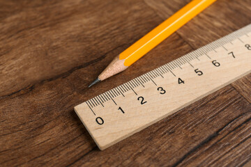 Ruler and pencil on wooden table, closeup